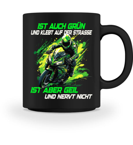 Eine Tasse für Motorradfahrer von Wingbikers, mit dem beidseitigen Aufdruck, Ist auch grün und klebt auf der Straße, ist aber geil und nervt nicht, in schwarz.