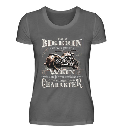 Ein Bikerin T-Shirt für Motorradfahrerinnen von Wingbikers mit dem Aufdruck, Eine Bikerin ist wie guter Wein - mit den Jahren entfaltet sie ihren einzigartigen Charakter - in dunkelgrau.