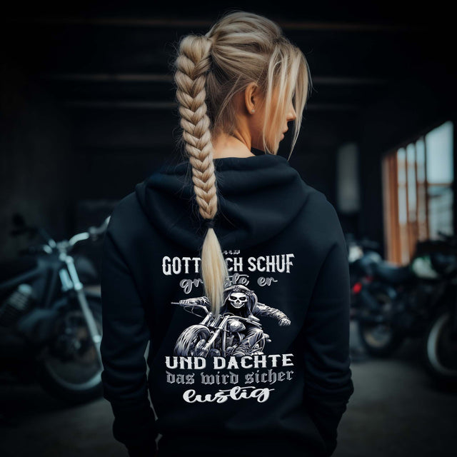 Ein Bikerin mit einem Damen Hoodie für Motorradfahrerinnen von Wingbikers mit dem Aufdruck, Als Gott mich schuf grinste er und dachte, das wird sicher lustig - mit Back Print, in schwarz.