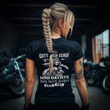 Eine Bikerin mit einem T-Shirt für Motorradfahrerinnen von Wingbikers mit dem Aufdruck, Als Gott mich schuf grinste er und dachte, das wird sicher lustig - mit Back Print, leger geschnitten, in schwarz.