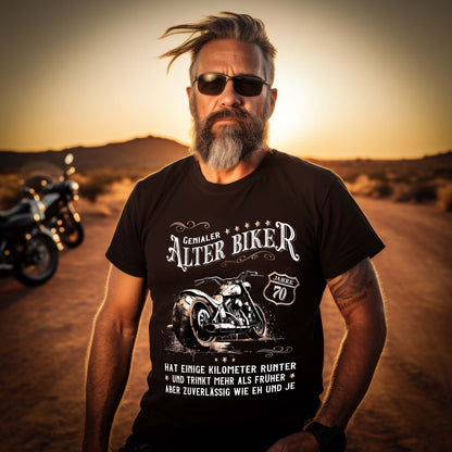 Ein Biker Geburtstags- T-Shirt für Motorradfahrer von Wingbikers mit dem Aufdruck, Alter Biker - 70 Jahre - Einige Kilometer runter, trinkt mehr - aber zuverlässig wie eh und je - in schwarz.