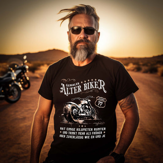 Ein Biker Geburtstags- T-Shirt für Motorradfahrer von Wingbikers mit dem Aufdruck, Alter Biker - 77 Jahre - Einige Kilometer runter, trinkt mehr - aber zuverlässig wie eh und je - in schwarz.