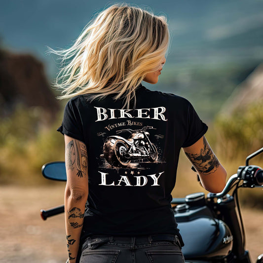 Eine Frau mit einem T-Shirt mit V-Ausschnitt für Motorradfahrerinnen von Wingbikers mit dem Aufdruck, Biker Lady mit einer vintage Chopper, als Back Print, in schwarz.