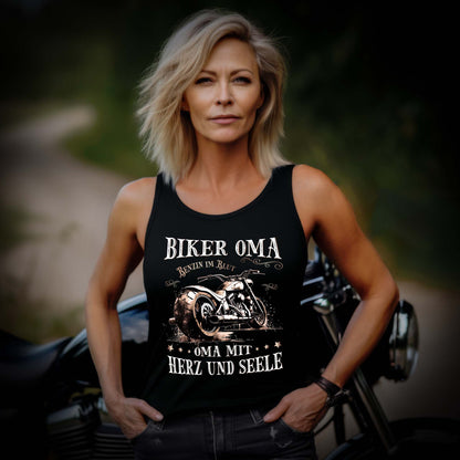 Eine Frau mit einem Tanktop für Motorradfahrerinnen von Wingbikers mit dem Aufdruck, Biker Oma - Benzin im Blut - Oma mit Herz und Seele, in schwarz.