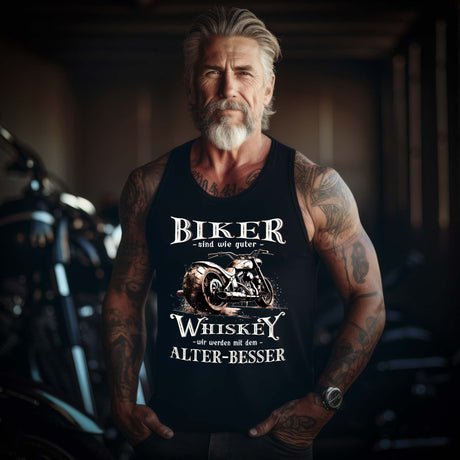 Ein Biker mit einem Tanktop von Wingbikers mit einem vintage Aufdruck, Biker sind wie gute Whiskey - wir werden mit dem Alter besser in schwarz.