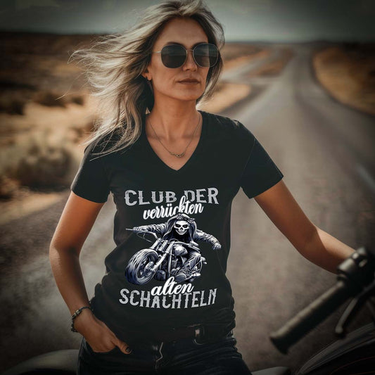 Eine Bikerin mit einem T-Shirt mit V-Ausschnitt für Motorradfahrerinnen von Wingbikers mit dem Aufdruck, Club der verrückten alten Schachteln - in schwarz.