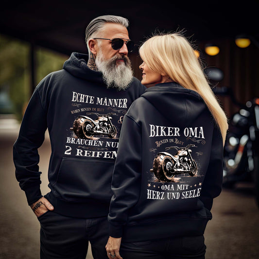 Eine Frau mit einer Reißverschluss-Jacke für Motorradfahrerinnen von Wingbikers mit dem Aufdruck, Biker Oma - Benzin im Blut - Oma mit Herz und Seele, in schwarz.