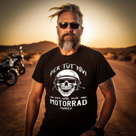 Ein Biker mit einem T-Shirt für Motorradfahrer von Wingbikers mit dem Aufdruck, Der tut nix - Der will nur Motorrad fahren - in schwarz.