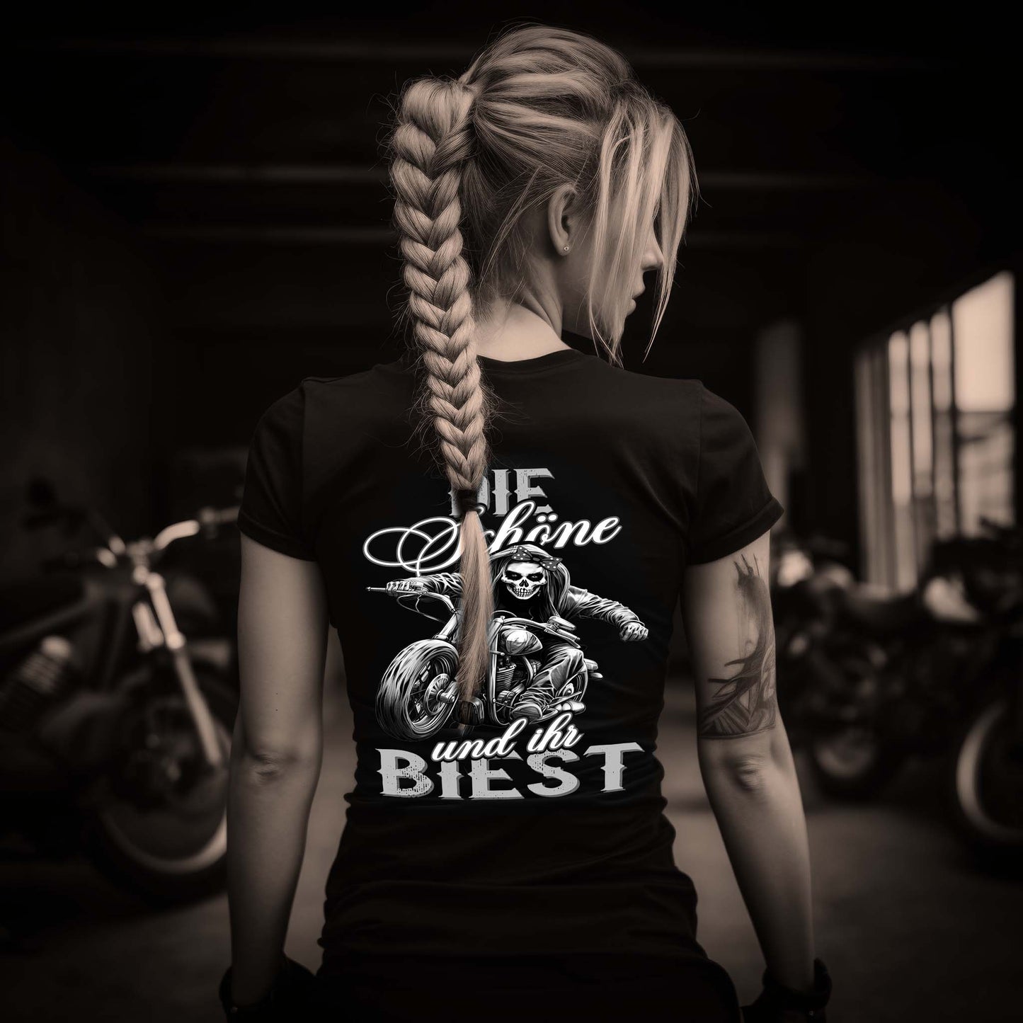 Eine Bikerin mit einem T-Shirt für Motorradfahrerinnen von Wingbikers mit dem Aufdruck, Die Schöne und ihr Biest - mit Back Print, leger geschnitten, in schwarz.