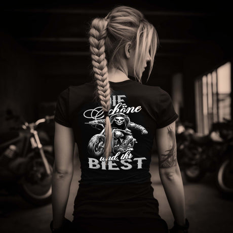 Eine Bikerin mit einem T-Shirt mit V-Ausschnitt für Motorradfahrerinnen von Wingbikers mit dem Aufdruck, Die Schöne und ihr Biest - mit Back Print, in schwarz.