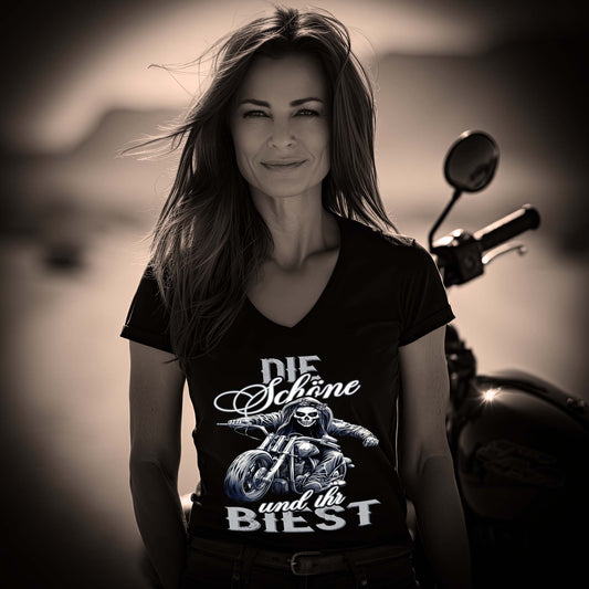Eine Bikerin mit einem T-Shirt mit V-Ausschnitt für Motorradfahrerinnen von Wingbikers mit dem Aufdruck, Die Schöne und ihr Biest - in schwarz.
