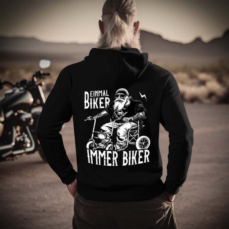 Ein Biker mit einem Hoodie für Motorradfahrer von Wingbikers mit dem Aufdruck, Einmal Biker - Immer Biker - mit Back Print, in schwarz.