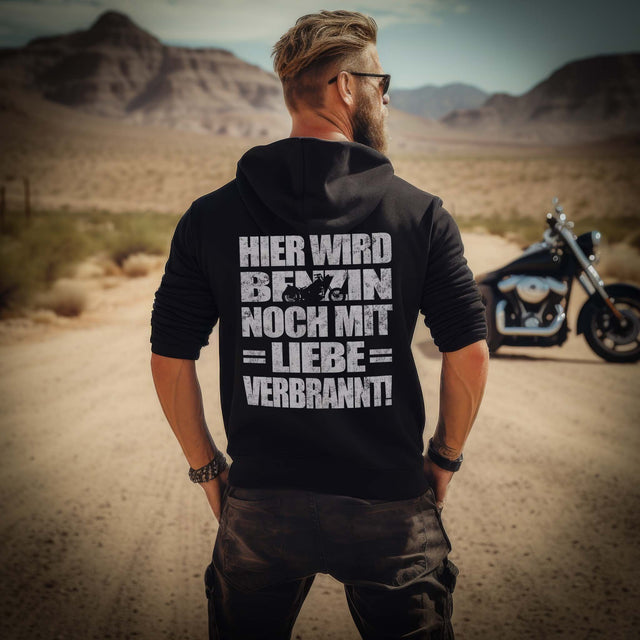 Ein Biker mit einem Hoodie für Motorradfahrer von Wingbikers mit dem Aufdruck, Hier wird Benzin noch mit Liebe verbrannt - mit Back Print, in schwarz.