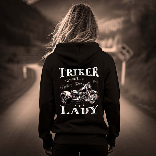 Eine Frau mit einem Damen Hoodie für Trike Fahrerinnen von Wingbikers mit dem Aufdruck, Triker Lady - Triker Life, im vintage Stil, als Back Print, in schwarz.