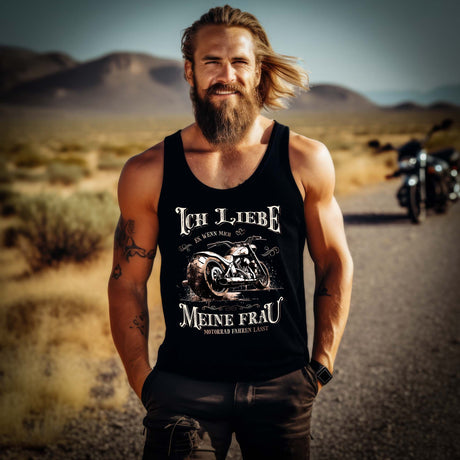 Ein Biker mit einem Tanktop für Motorradfahrer von Wingbikers mit dem Aufdruck, Ich liebe meine Frau, wenn sie mich Motorrad fahren lässt! - in schwarz.