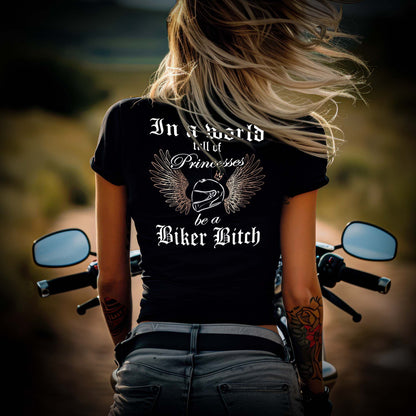 Eine Bikerin mit einem T-Shirt mit V-Ausschnitt für Motorradfahrerinnen von Wingbikers mit dem Aufdruck, In a world full of Princesses, be a Biker Bitch - mit Back Print, in schwarz.