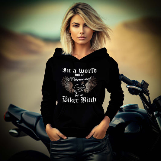 Eine Bikerin mit einem Damen Hoodie für Motorradfahrerinnen von Wingbikers mit dem Aufdruck, In a world full of Princesses, be a Biker Bitch - in schwarz.