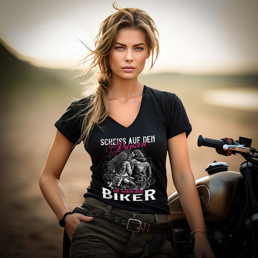 Ein Motorradfahrerin mit einem T-Shirt mit V-Ausschnitt von Wingbikers mit dem Aufdruck, Scheiß auf den Prinzen, ich nehm' den Biker, in schwarz.