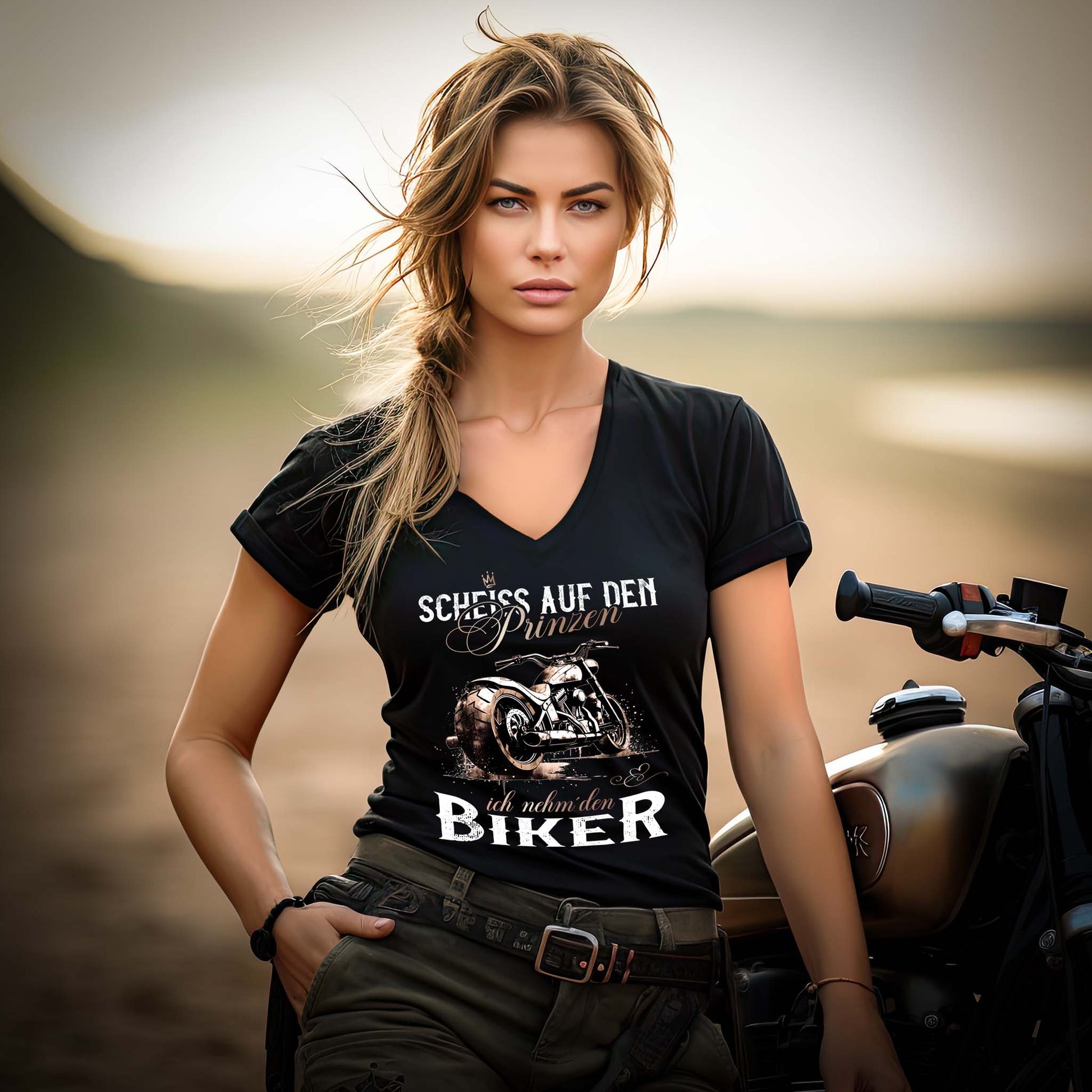 Eine Motorradfahrerin mit einem T-Shirt mit V-Ausschnitt von Wingbikers mit dem Aufdruck, Scheiß auf den Prinzen, ich nehm' den Biker, in schwarz.