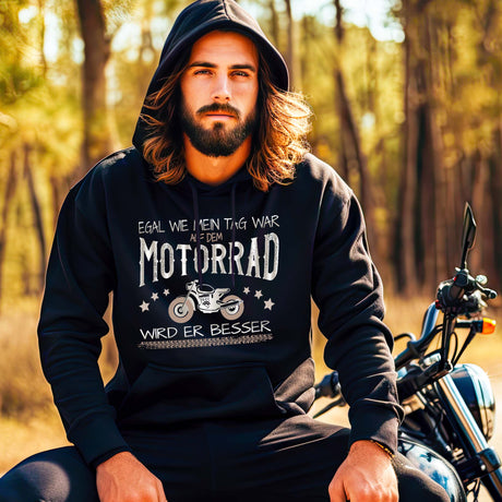 Ein Motorradfahrer mit einem Hoodie von Wingbikers mit dem Aufdruck, Egal wie mein Tag war, auf dem Motorrad wird er besser, in schwarz.