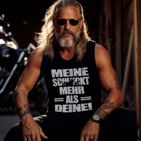 Ein Biker mit einem Tanktop für Motorradfahrer von Wingbikers mit dem Aufdruck, Meine schluckt mehr als deine! mit einem Motorrad, in schwarz.