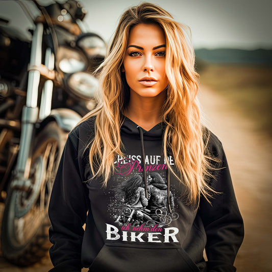 Eine Motorradfahrerin mit einem Damen Hoodie von Wingbikers mit dem Aufdruck, Scheiß auf den Prinzen, ich nehm' den Biker, in schwarz.