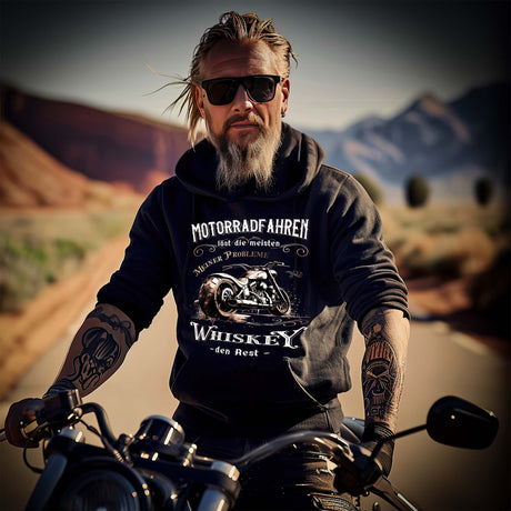 Ein Biker mit einem Hoodie für Motorradfahrer von Wingbikers mit dem Aufdruck, Motorradfahren löst die meisten meiner Probleme - Whiskey den Rest - in schwarz.