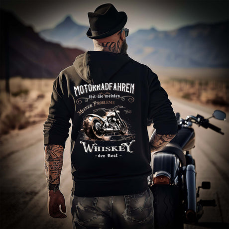 Ein Biker mit einem Hoodie für Motorradfahrer von Wingbikers mit dem Aufdruck, Motorradfahren löst die meisten meiner Probleme - Whiskey den Rest - mit Back Print, in schwarz.