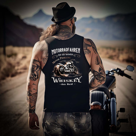 Ein Biker mit einem Tanktop für Motorradfahrer von Wingbikers mit dem Aufdruck, Motorradfahren löst die meisten meiner Probleme - Whiskey den Rest - mit Back Print, in schwarz.