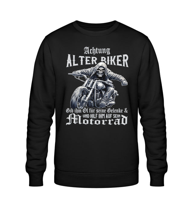 Ein Biker Sweatshirt für Motorradfahrer von Wingbikers mit dem Aufdruck, Achtung alter Biker - Gib ihm Öl und hilf ihm auf sein Motorrad - in schwarz.