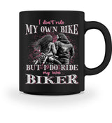 Eine Tasse für Motorradfahrerinnen von Wingbikers, mit dem beidseitigen Aufdruck, I Don't Ride My Own Bike, But I Do Ride My Own Biker, in schwarz.