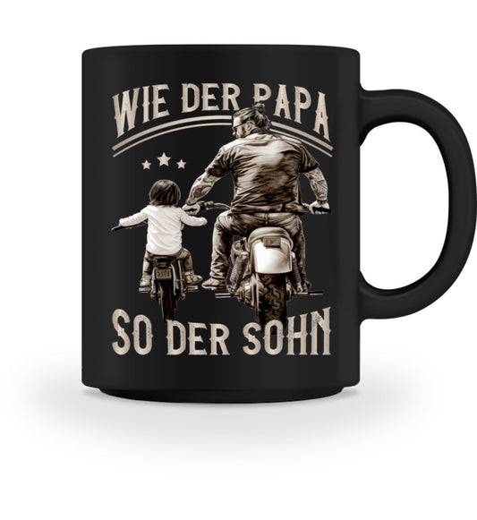 Eine Tasse für Motorradfahrende Väter von Wingbikers, mit dem beidseitigen Aufdruck, Wie der Papa, so der Sohn, in schwarz.
