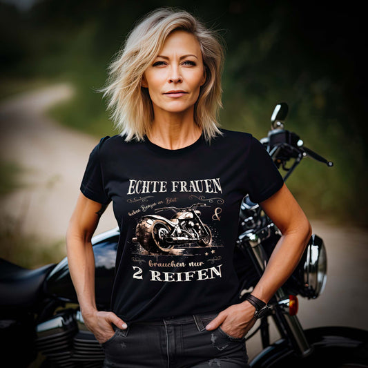 Eine Motorradfahrerin mit einem T-Shirt von Wingbikers mit dem Aufdruck, Echte Frauen brauchen nur zwei Reifen, in schwarz.