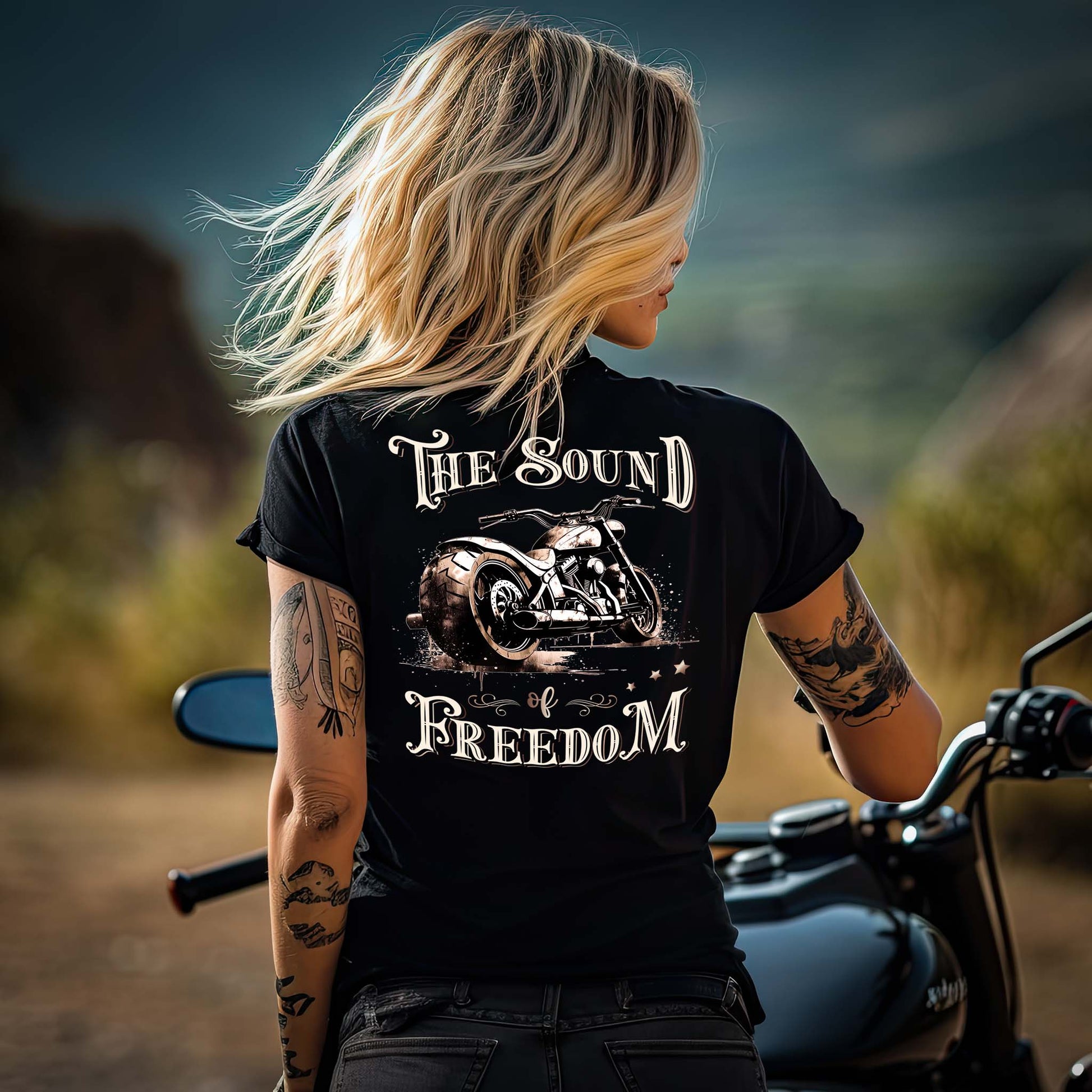 Eine Motorradfahrerin mit einem T-Shirt mit V-Ausschnitt von Wingbikers mit dem Aufdruck, The Sound auf Freedom, als Backprint in schwarz.
