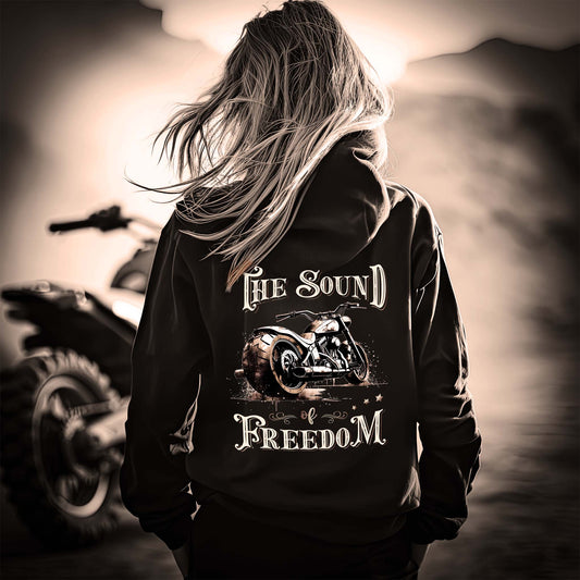 Eine Motorradfahrerin mit einem Hoodie von Wingbikers mit dem Aufdruck, The Sound auf Freedom, als Backprint in schwarz. 