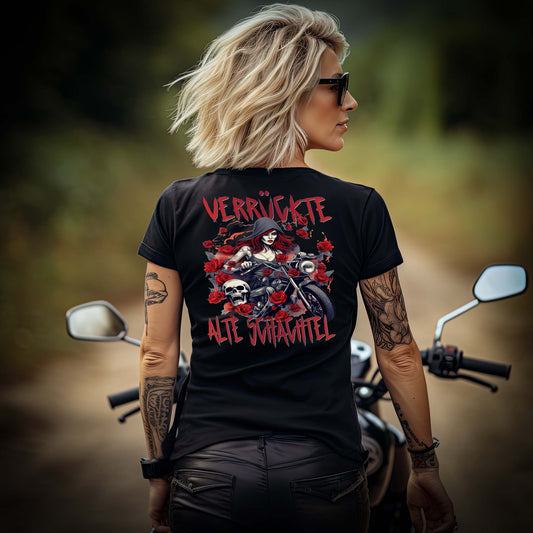 Ein Frau mit einem T-Shirt mit V-Ausschnitt für Motorradfahrerinnen von Wingbikers mit dem Aufdruck, Verrückte alte Schachtel, als Back Print, in schwarz.