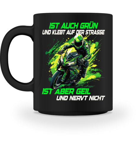 Eine Tasse für Motorradfahrer von Wingbikers, mit dem beidseitigen Aufdruck, Ist auch grün und klebt auf der Straße, ist aber geil und nervt nicht, in schwarz.