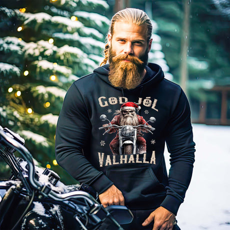 Ein Biker mit einem weihnachtlichen Hoodie für Motorradfahrer von Wingbikers mit dem Aufdruck, God Jól Valhalla - in schwarz.