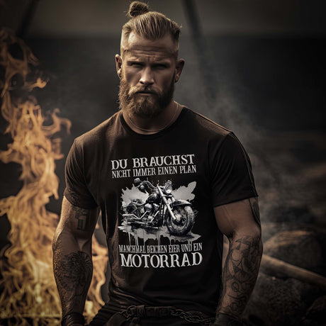 Ein Motorradfahrer mit einem Biker T-Shirt von Wingbikers mit dem Aufdruck, Du brauchst nicht immer einen Plan - Manchmal reichen Eier und ein Motorrad - in schwarz.