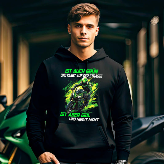 Ein Motorradfahrer mit einem Hoodie von Wingbikers mit dem Aufdruck, Ist auch grün und klebt auf der Straße, ist aber geil und nervt nicht, in schwarz.