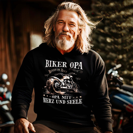Ein Biker mit einem Hoodie für Motorradfahrer von Wingbikers mit dem Aufdruck, Biker Opa - Benzin im Blut - Opa mit Herz und Seele, in schwarz.