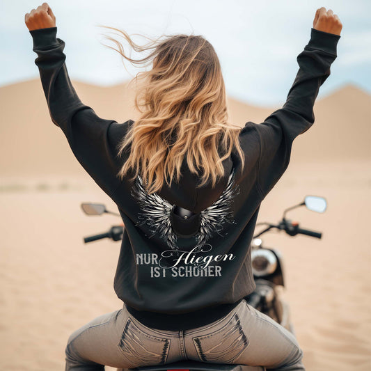 Ein Motorradfahrerin mit einem Damen Hoodie von Wingbikers mit dem Aufdruck, Nur fliegen ist schöner, in schwarz.