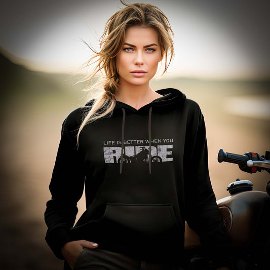 Eine Frau mit einem Hoodie für Motorradfahrerinnen von Wingbikers mit dem Aufdruck, Life Is Better When You Ride - mit Motorrad, in schwarz.