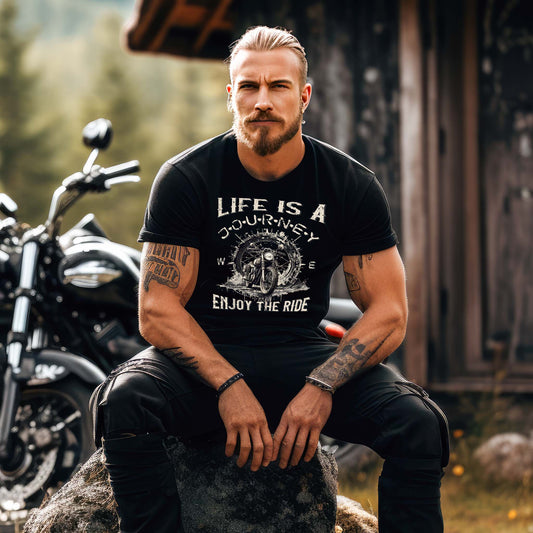 Ein Biker mit einem T-Shirt für Motorradfahrer von Wingbikers mit dem Aufdruck, Life Is A Journey - Enjoy The Ride, in schwarz.