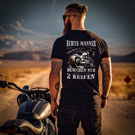 Ein Biker mit einem T-Shirt für Motorradfahrer von Wingbikers mit dem Aufdruck, Echte Männer brauchen nur 2 Reifen, als Back Print, in schwarz.