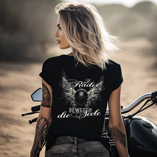 Eine Frau mit einem T-Shirt mit V-Ausschnitt für Motorradfahrerinnen von Wingbikers mit dem Aufdruck, Zwei Räder bewegen die Seele - mit einem Helm mit Flügeln, in schwarz.