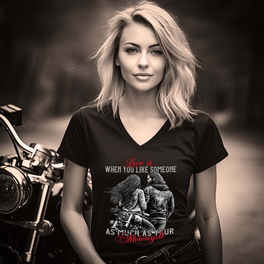 Eine Motorradfahrerin mit einem T-Shirt mit V-Ausschnitt von Wingbikers mit dem Aufdruck, Love is, When You Like Someone As Much As Your Motorcycle, in schwarz.