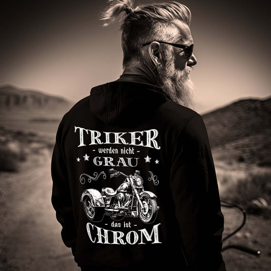 Ein Triker mit einer Reißverschluss-Jacke für Trikefahrer von Wingbikers mit dem Aufdruck, Triker werden nicht grau - Das ist Chrom, in schwarz.
