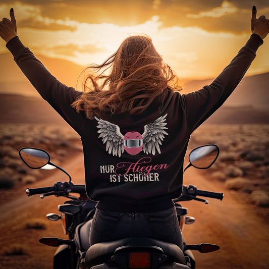 Eine Motorradfahrerin mit einer Reißverschluss-Jacke von Wingbikers mit dem Aufdruck, Nur fliegen ist schöner, in schwarz.